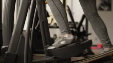 Jimnastik salonundaki bayan sporcular simülatörler üzerinde çalışıyor.