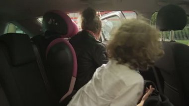 Güzel yetişkin anne, genç kız ve oğul için araba kapısını açıyor ve sabah derslerine gitmeden önce veda öpücüğü veriyor. Bakıcı anne çocukları okula bırakıyor..