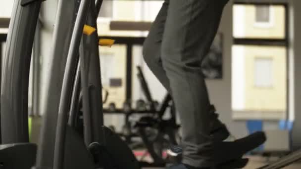 Çekici yaşlı beyaz kadın antrenman makinesinde çalışıyor ve fitness merkezinde mutlu görünüyor. Orta yaşlarda spor ve spor — Stok video