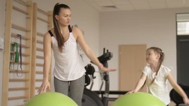 Mamá y su hija están haciendo en el gimnasio . — Vídeo de stock