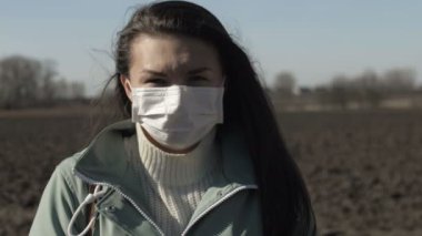 Coronavirus konsepti. Dışarıda koruyucu maske takan bir kadının portresi. Covid-19 sağlık ve güvenlik kavramı