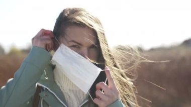 Kadın Coronavirus COVID-19 'a karşı korunmak için maske takıyor. Dışarıda koruyucu maske takan bir kızın portresi.