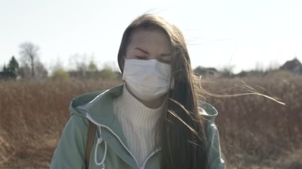 Junge Frau mit Gesichtsmaske auf der Straße. Neuartiges Coronavirus-Selbstschutzkonzept — Stockvideo