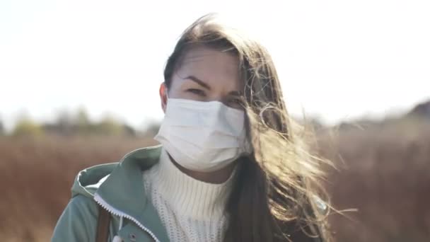 Женщина снимает хирургическую маску, избегая тесного контакта с больными . — стоковое видео