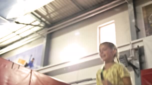 Linda chica en edad escolar está saltando en un trampolín. Niño es feliz . — Vídeos de Stock