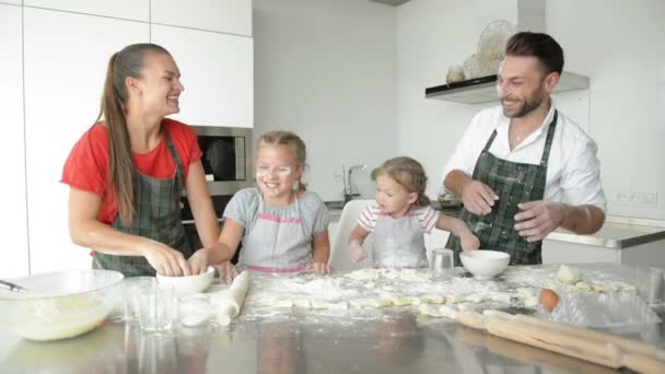 Pap, mam en twee zussen begonnen een komisch gevecht tijdens het bereiden van het diner. Ze besprenkelen elkaar met bloem.. — Stockvideo