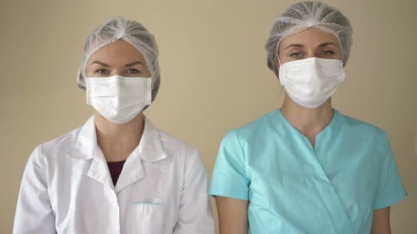 Bitte bleiben Sie zu Hause. Krankenschwestern mit einem Plakat. Empfehlung Quarantäne zur Verhinderung von Coronovirus-Covid19. — Stockvideo