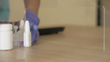 Koruyucu eldivenli bir eczacının elleri müşteriye ilaç servisi yapar. Virüs koruması.