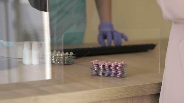 A védőkesztyűs gyógyszerész kezei gyógyszereket szolgálnak fel az ügyfélnek. Vírusvédelem. — Stock videók