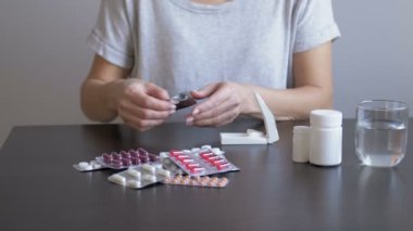 Tahta bir masanın üstünde hap kesiciyle tableti paylaşan bir kadının elleri, uyuşturucu kullanan bir kızın, ilaç geçmişi