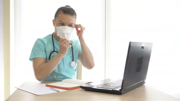 O médico usa o laptop para consulta remota durante a quarentena . — Vídeo de Stock