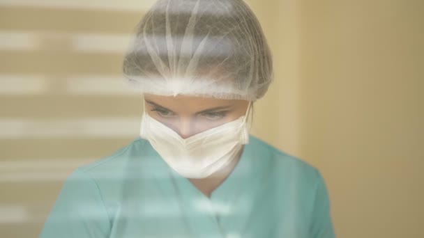 Nurse in a medical mask and a disposable cap. Virus protection. — Stock Video