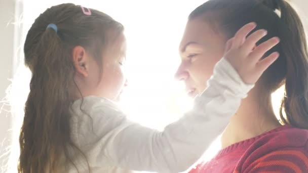 Close-up van de strakke knuffelen van de mooie moeder en haar dochtertje thuis in de dag — Stockvideo