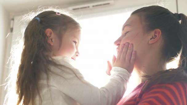 Hija besando a su madre feliz y la abraza, están en casa. Feliz día de las madres — Vídeos de Stock