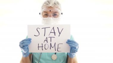 Genç bayan doktor elinde hashtag 'i olan bir kağıt tutuyor. Coronavirüs salgını.