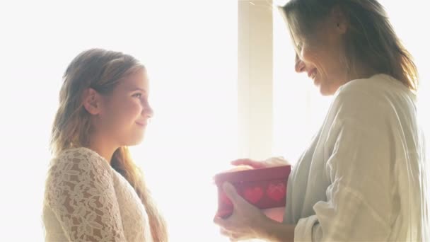 Маленькая милая девочка улыбается давая подарочную коробку счастливой маме, поздравления, празднуя День матери — стоковое видео