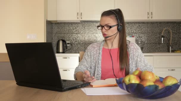 Jovem com fone de ouvido na frente do laptop na mesa, consulta ao cliente on-line . — Vídeo de Stock