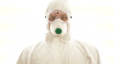 Koruyucu takım elbiseli adam tabelayı evde tutuyor. Salgın, Coronavirus covid 19 salgını..