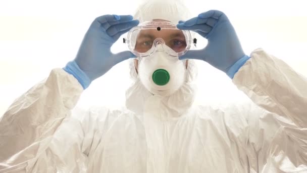 L'homme dans un respirateur et des vêtements de protection met des lunettes et fait un signe d'interdiction de ses propres mains. épidémie de coronavirus . — Video