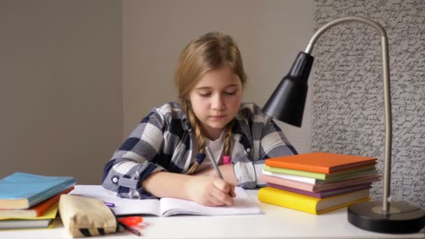 Cute schoolgirl diligently does her homework. Self-study activities. — Stock Video