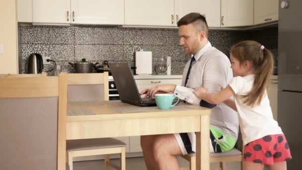 De jongeman werkt thuis aan de computer vanwege de quarantaine. Kleine dochter houdt hem tegen om te werken.. — Stockvideo