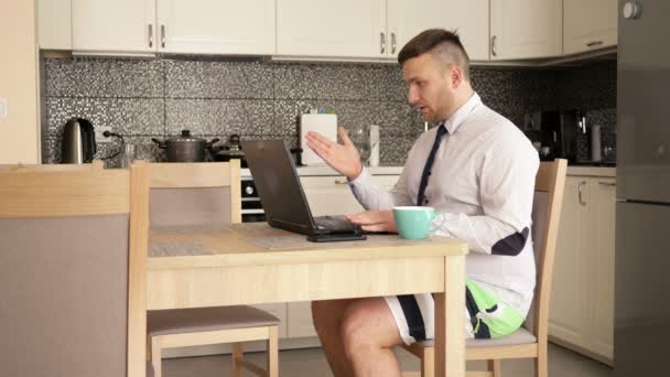 Teletrabajo. Conferencia de Internet. El hombre de negocios lleva una camisa con corbata y pantalones cortos. Él está hablando por Skype con los empleados . — Vídeo de stock