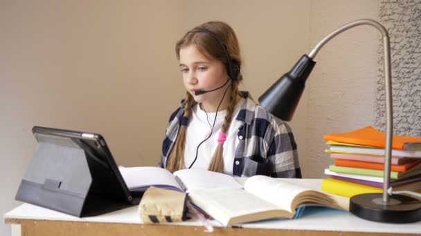 Flickan kommunicerar med läraren via Internet. Utbildning online under karantänen. — Stockvideo