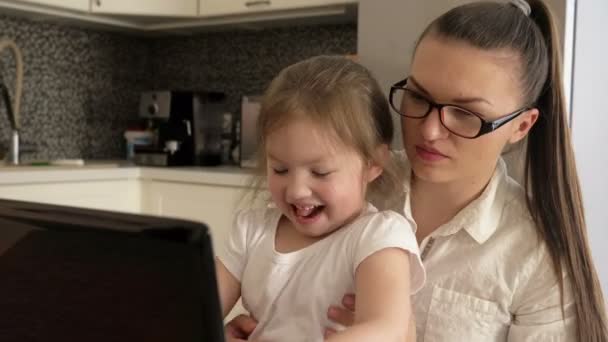 Uzaktan çalış. Genç Bisnesswoman evde bir dizüstü bilgisayar üzerinde çalışıyor. Küçük kız annenin çalışmasını engelliyor. Çocuk oynamak istiyor.. — Stok video