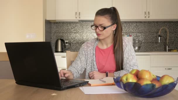 Travail en ligne. Une jeune femme travaille au bureau à domicile. Capacité de travailler pendant la quarantaine . — Video