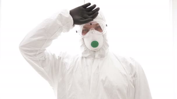 Портрет втомленого молодого лікаря в захисному одязі під час пандемії коронавірусу. Епідемія, пандемія коронавірусної інфекції 19 . — стокове відео