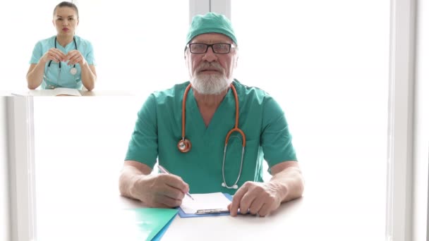 Telekonference. Starší lékař radí mladému kolegovi. — Stock video