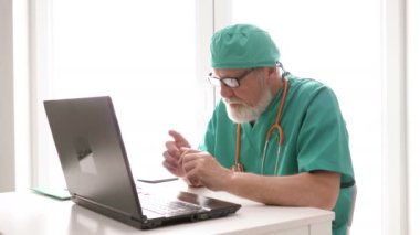 Çevrimiçi doktor. Deneyimli bir doktor dizüstü bilgisayarını kullanan bir hastaya danışır. Covid-19 Salgını.