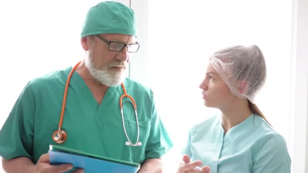 Médico e enfermeiro examinando os prontuários dos pacientes . — Vídeo de Stock