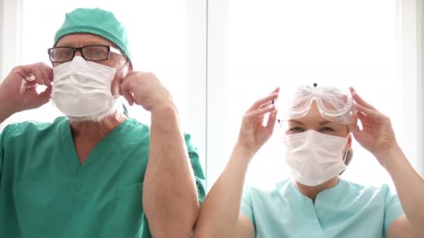 Zmęczony lekarz i pielęgniarka zdjąć maski medyczne. — Wideo stockowe