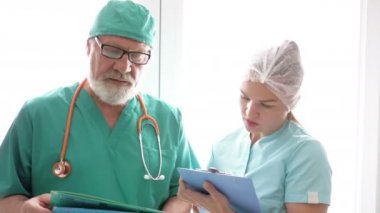 Doktor ve hemşire hastane raporlarını kontrol ediyor..