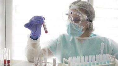 COVID-19 testi. Laboratuvar asistanı kadının ellerinde Coronavirus enfeksiyonu teşhisi için yapılan kan testlerinin laboratuvar örneği..