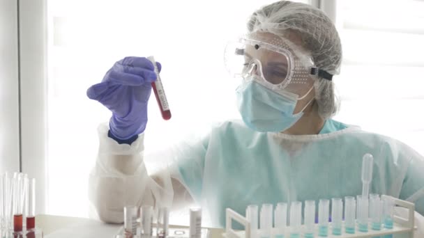 COVID-19 테스트. 실험실 보조원 여자의 손에 있는 진단 코로나 바이러스 감염 여부를 검사하기 위한 혈액 샘플. — 비디오