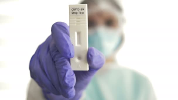Vrouwelijke laboratoriumassistent toont een striptest. 10 minuten coronavirus diagnose. — Stockvideo