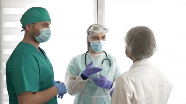 Група лікарів у захисних костюмах обговорює медичні питання . — стокове відео