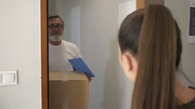 Kurye bir paket teslim eder, genç bir kadın bir kutu alır. Teslimat servisi.