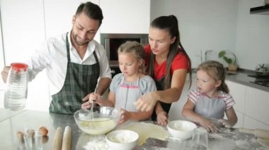 Baba, annem ve iki kız kardeşim mutfakta bir şeyler pişiriyorlar. Çocuklar için bu eğlenceli bir oyun..