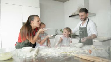 Baba, annem ve iki kız kardeşim mutfakta bir şeyler pişiriyorlar. Çocuklar için bu eğlenceli bir oyun..