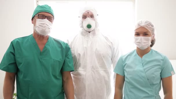 Team of doctors in protective clothing shows with their own hands a gesture all is well. — Stock Video