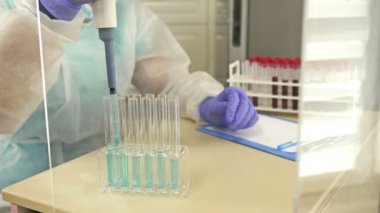 Laboratuvar teknisyeni reaktörü kan dolu bir test tüpüne yerleştiriyor..