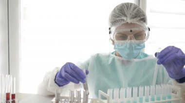 COVID-19 testi. Laboratuvar asistanı kadının ellerinde Coronavirus enfeksiyonu teşhisi için yapılan kan testlerinin laboratuvar örneği..