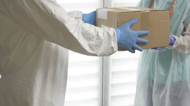 Der Freiwillige gibt dem Arzt Boxen mit den notwendigen Medikamenten und persönlicher Schutzausrüstung. Wohltätigkeit während der COVID-19-Epidemie. — Stockvideo