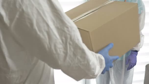 Dobroczynność podczas epidemii COVID-19. Wolontariusz podaje lekarzowi pudełko z niezbędnymi lekami. — Wideo stockowe