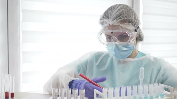 Анализ крови на ковид-19 в лаборатории. Женщина лаборант, работающая с диспенсером. — стоковое видео