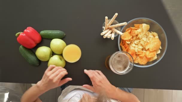 Difficulté à choisir entre une alimentation saine et malsaine. La femme choisit des aliments sains. Vue d'en haut . — Video