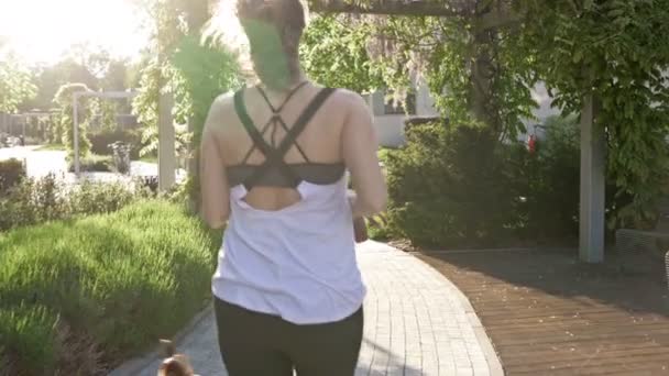 Femme athlétique jogging avec son chien. Mode de vie sain. Vue arrière . — Video